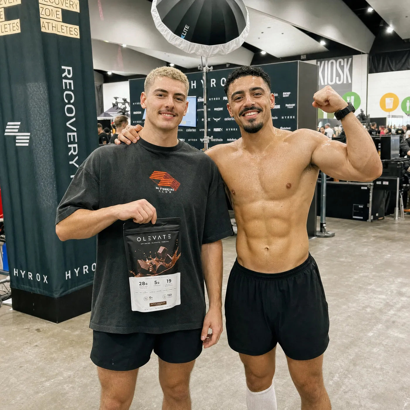 Two people with the OLEVATE chocolate pouch at a fitness event