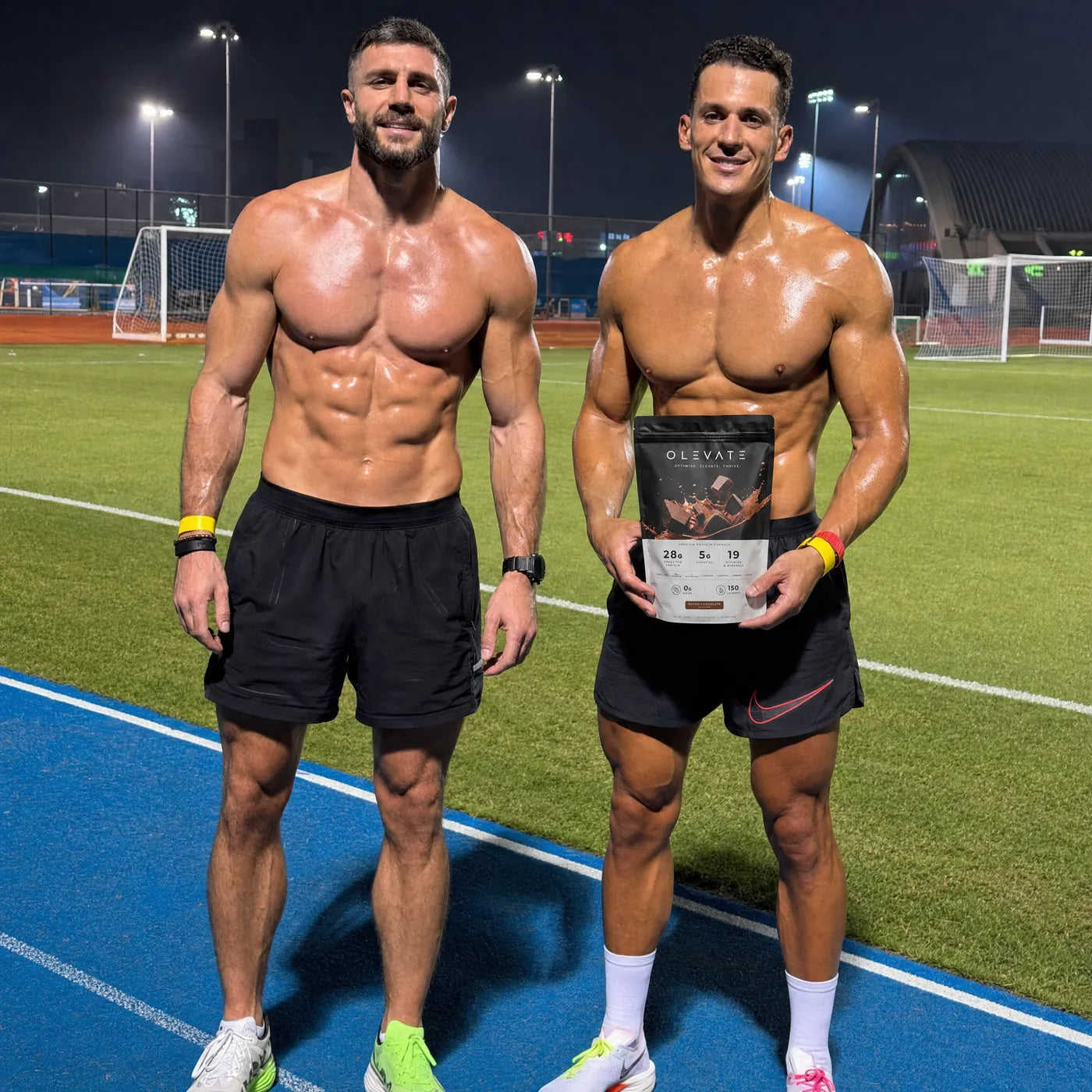Two people on a sports field holding the OLEVATE chocolate pouch